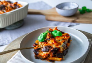 Teller mit Penne alla Siciliana auf dem Esstisch